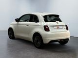 the small white car is parked in a large room