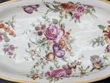 a large oval platter with flowers and birds on it
