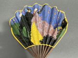 a fan with a painting on it hanging on a wall