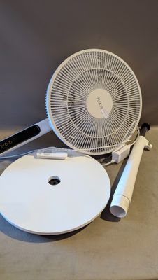un éventail blanc posé sur une table, à côté d'une assiette blanche