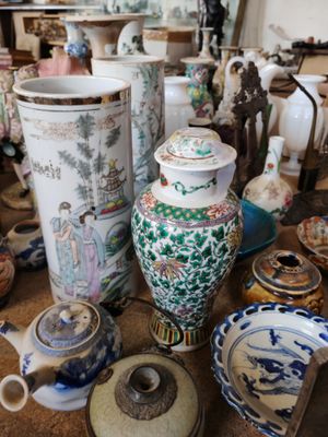 de nombreux vases et bols de toutes sortes sur la table