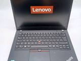 the laptop is open on a white surface with a red lenovo logo on the screen