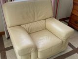 a white leather chair sitting in front of a window