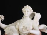 someone is holding a white figurine of a woman with flowers in her hands