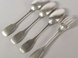 five silver spoons and a fork are lined up on a table