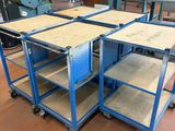 un ensemble de quatre tables en métal bleu posées sur un parquet en bois massif