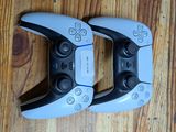 two video game controllers sitting on a wooden floor