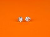 une paire de boucles d'oreilles en diamant sur fond orange