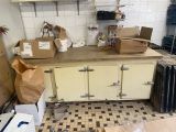 une cuisine où il y a plein de cartons, les uns sur les autres, sur le plan de travail