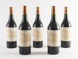 four bottles of wine are lined up on a white surface