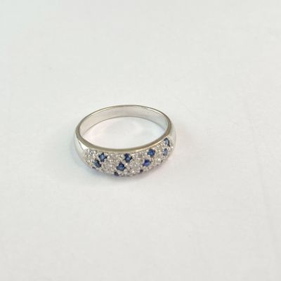 gros plan d'une bague en diamant et saphir sur une surface blanche