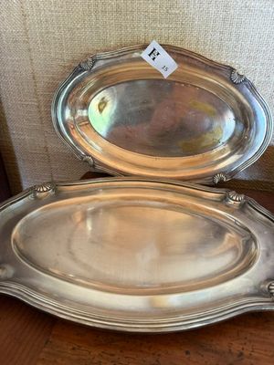 deux plateaux en métal argenté posés sur une table en bois, avec une étiquette de prix