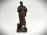an old bronze statue of a man holding a cane