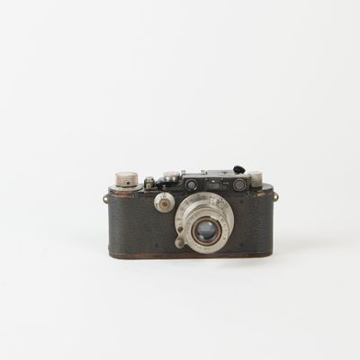 un petit appareil photo posé sur une surface blanche