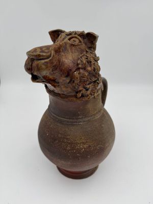 un vase marron orné d'une tête de chien