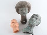three clay sculptures of a woman and a fish