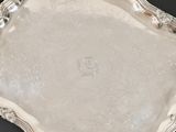 a silver tray with a handle on a black surface