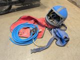 a welding helmet and hose on the floor in a garage