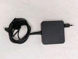 the black charger is plugged into the wall with a cord