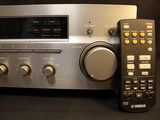 a remote next to a stereo system on a table
