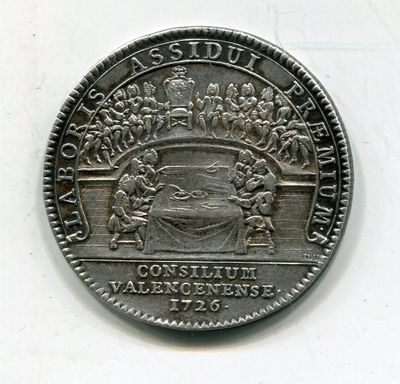une vieille pièce de monnaie sur laquelle figure l'image d'un groupe de personnes
