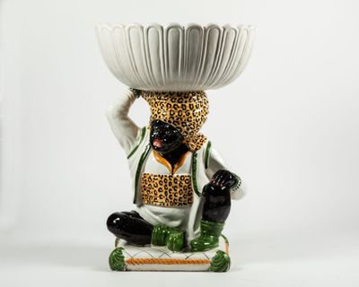 une figurine représentant un homme tenant un bol sur la tête