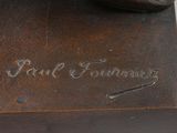 statue of a man holding a tennis racquet on top of a wooden base