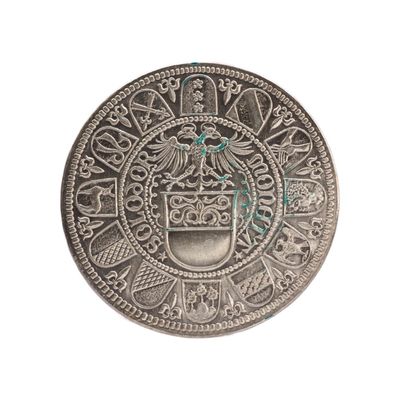 un gros plan d'une pièce d'argent sur laquelle figure un blason