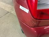 a close up of a red car with a sticker on it ' s tail light