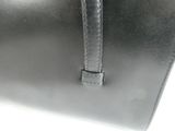 the large black bag is sitting on a white surface