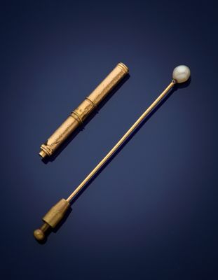un bâtonnet doré et nacré, ainsi qu'une boule nacrée, sur fond bleu