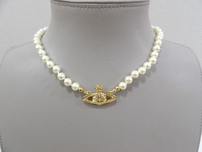 gold plated necklace with pearls and a gold plated eye charm