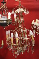 Lustre en métal doré à huit bras de lumière et pampilles.
