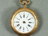 une montre de poche en or avec des chiffres romains sur le cadran