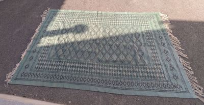 un tapis bleu posé par terre, sur lequel se dessine une ombre