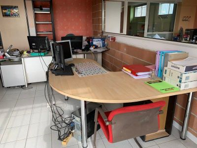 un bureau sur lequel se trouve un ordinateur, avec une chaise devant