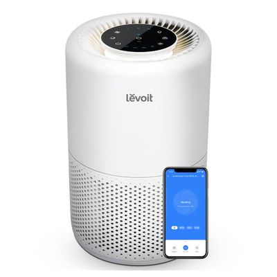 un purificateur d'air blanc à côté d'un smartphone