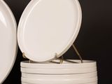 several white plates stacked on top of each other on a wooden table