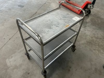 un petit chariot en métal muni d'une poignée rouge