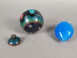 three small glass objects sitting on a white surface