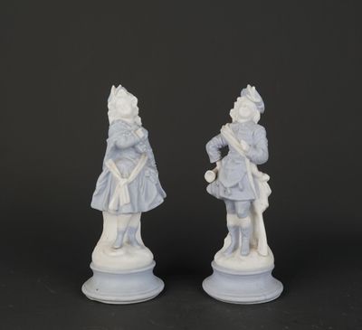 deux figurines blanches représentant un homme et une femme, posées sur un socle