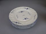 a stack of blue and white plates sitting on a table
