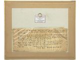 an old letter with a ring on top of it next to a piece of paper