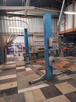 a picture of a garage with a checkered floor and a blue lift