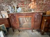 une grande armoire en bois surmontée d'un miroir