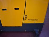 a close up of a yellow and black machine sitting on top of a floor