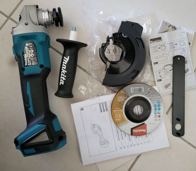 a cordless drill and other tools sitting on a tile floor