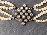 an image of a close up of a necklace with pearls and beads