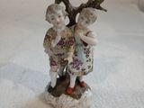 une figurine représentant deux enfants debout l'un à côté de l'autre