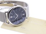 a close up of a wrist watch with a card on a white surface